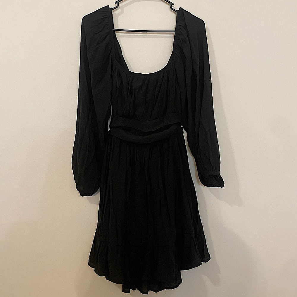 Black mini dress with long sleeves and a tie detail in the back. NWOT